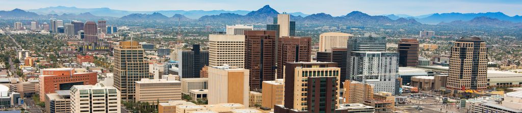 A city with many tall buildings and mountains in the background