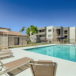 A pool with chairs and a fence