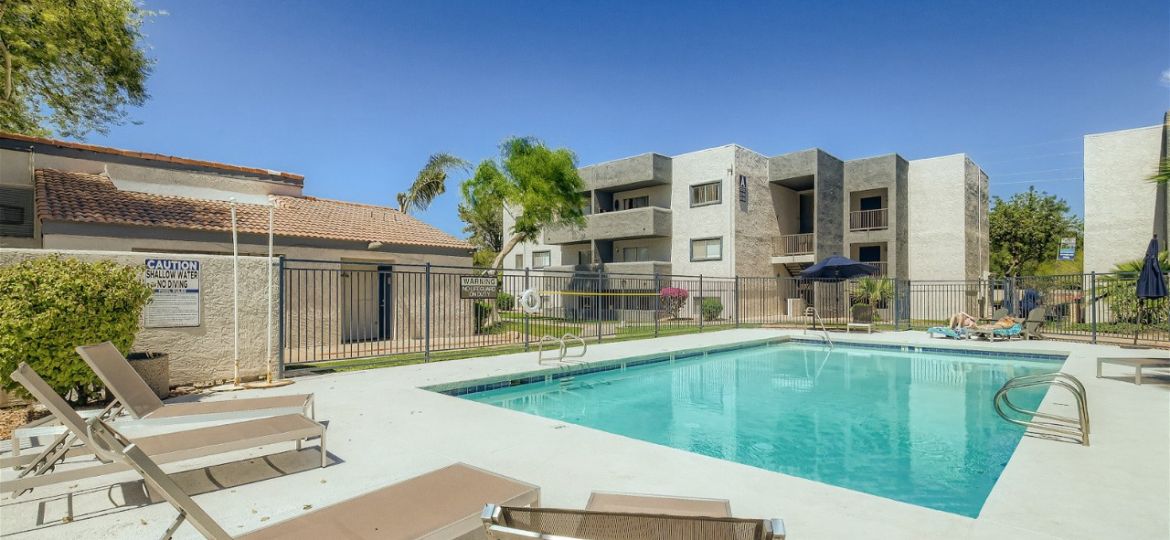 A pool with chairs and a fence