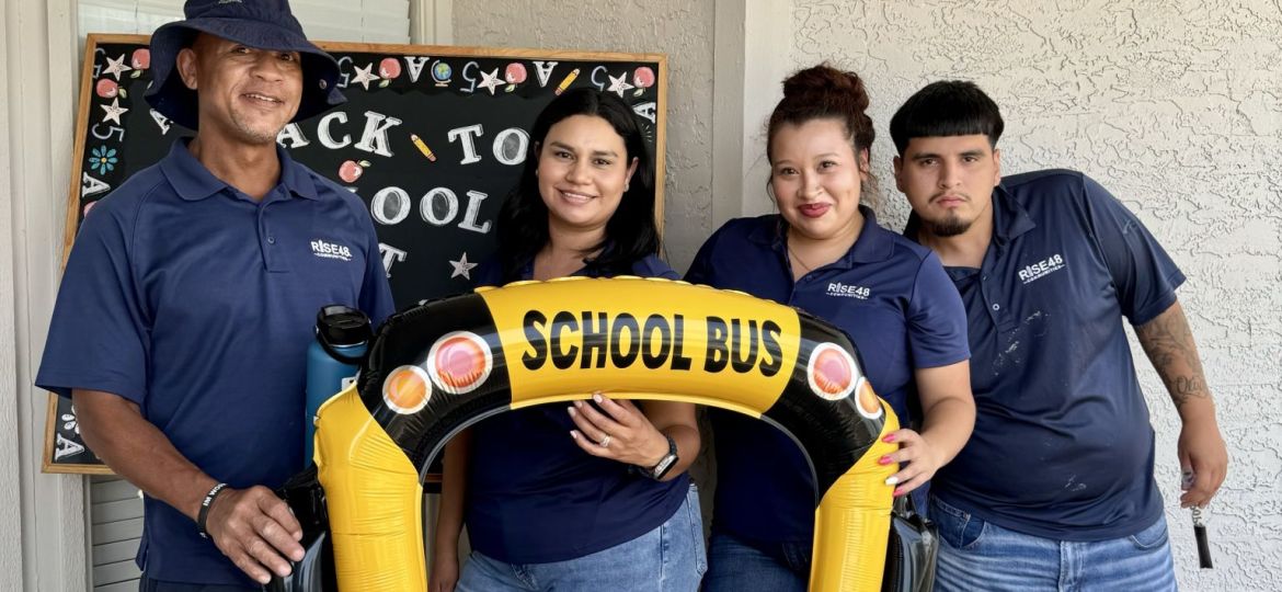 A group of people posing with a yellow inflatable object