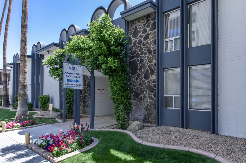 A building with a stone wall and a stone walkway